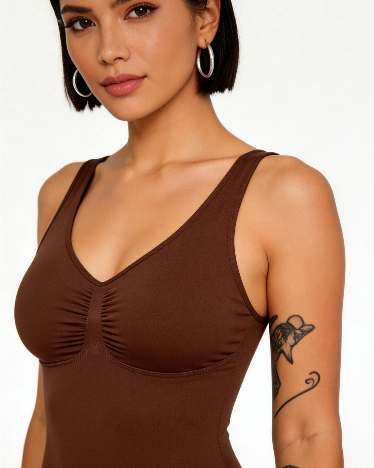 Woman wearing a brown tank top against a white background